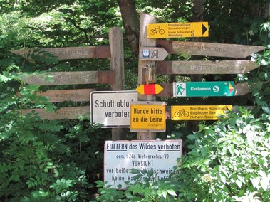 Auch durch den Ebersberger Forst verläuft der Weitwanderweg; Schilder-Ensemble bei Eglharting