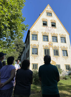 Sonja Fehler erklärt die Bedeutung der Fassadenmalerei des Schloßes Weikertsham © Museum Wasserburg.
